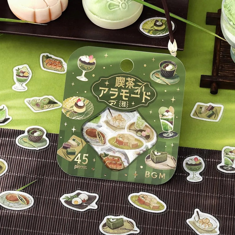 Green matcha-themed café flake sticker sheet with illustrated desserts, tea bowls and small plates accented with foil.
