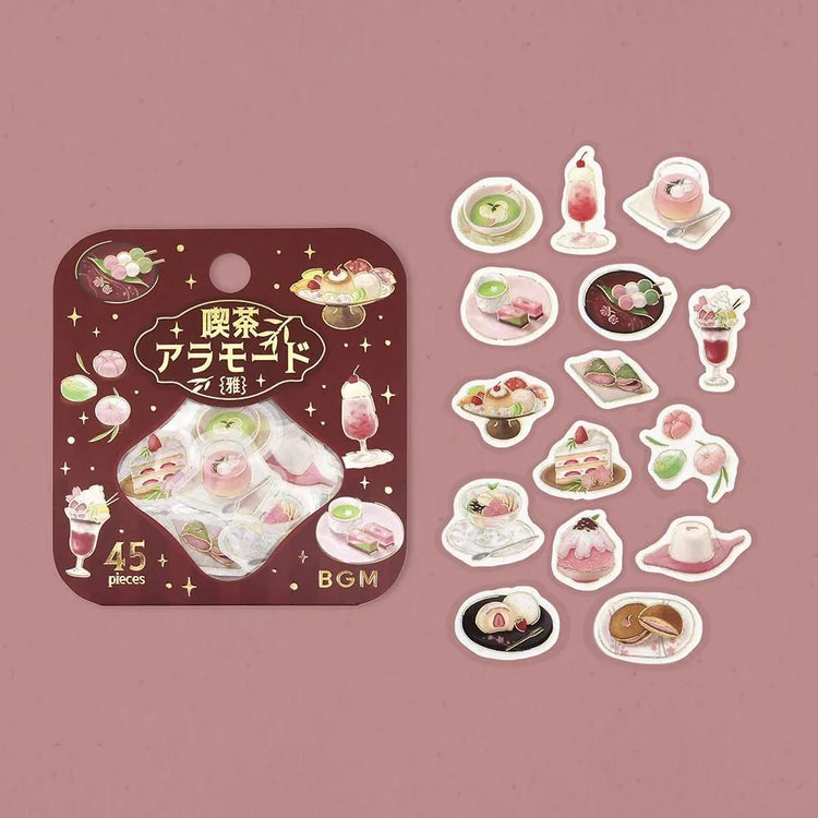 Pink-toned café flake stickers showing cakes, parfaits and delicate desserts with warm foil accents on washi paper.