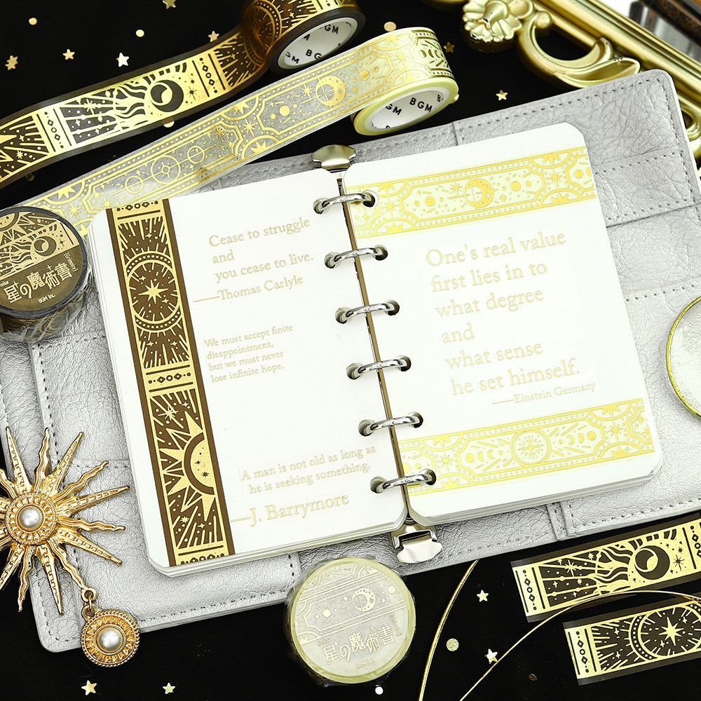 A roll of gold-toned washi tape with celestial suns, moons, and foil accents from the Grimoire of Stars Holy edition.