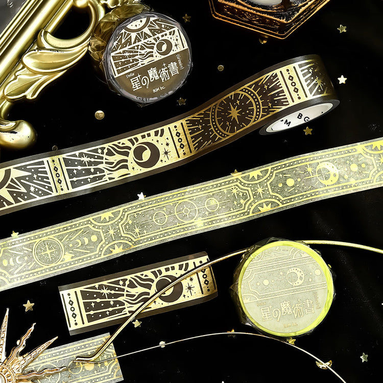 A roll of gold-toned washi tape with celestial suns, moons, and foil accents from the Grimoire of Stars Holy edition.
