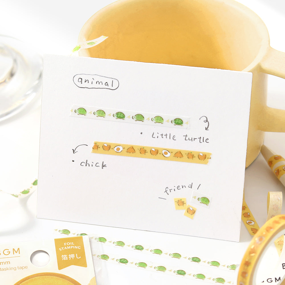 A slim roll of washi tape featuring a repeating design of playful yellow chicks running, accented with metallic foil highlights—perfect for planners, journaling, and decorative crafts.
