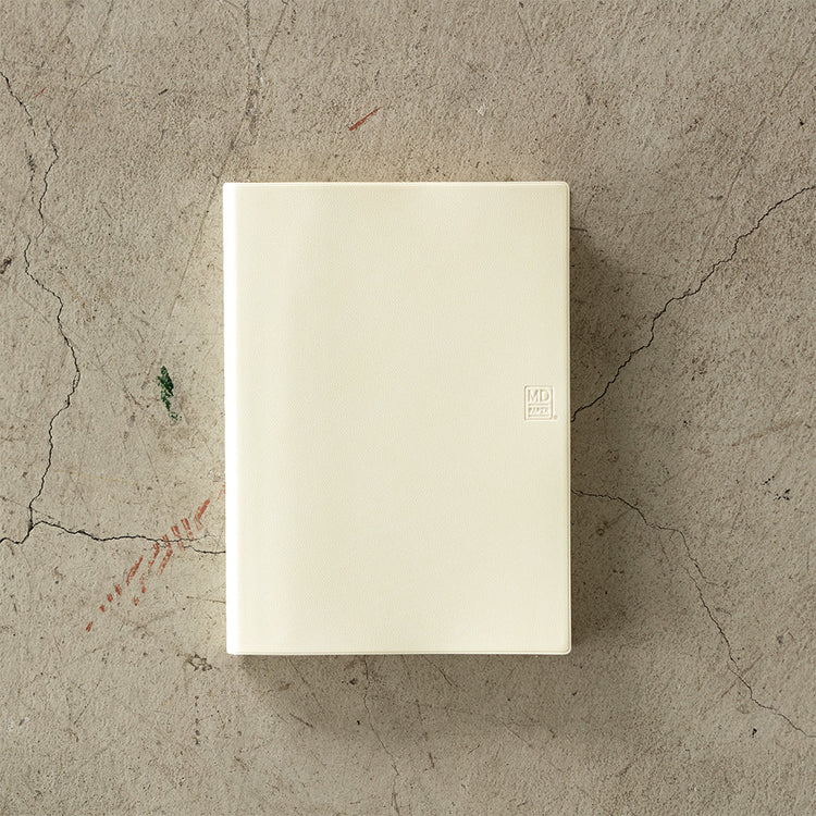 MD Notebook Diary (A5) 1 Day 1 Page 2026 with a minimalist PVC cover, year-stamped spine, and index tabs for each month. The diary is open to show a clean daily page layout on premium MD PAPER, ideal for journaling or planning.