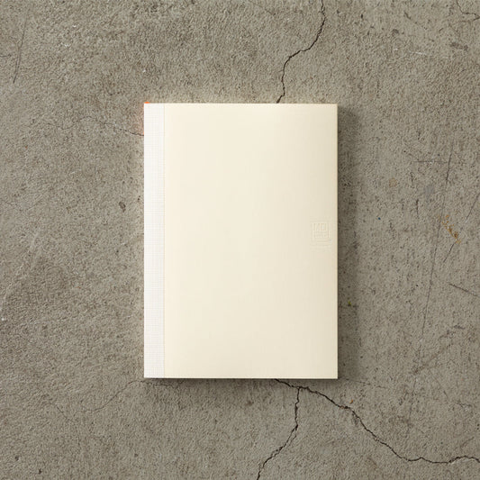 MD Notebook Diary (A5) Thin 2026 – A slim, thread-bound diary with a minimalist cream cover and glassine paper wrap, featuring monthly schedule pages, 5mm grid memo pages, and a bookmark string. Compact and lightweight, designed for portability and everyday use.