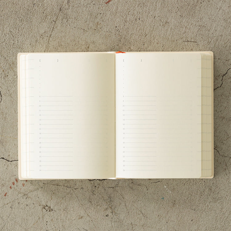 MD Notebook Diary (A6) 1 Day 1 Page 2026 with a minimalist PVC cover, featuring a year stamp on the spine, two bookmark strings, and monthly index tabs. The diary is open to reveal its premium MD PAPER with a clean, spacious layout for daily entries.
