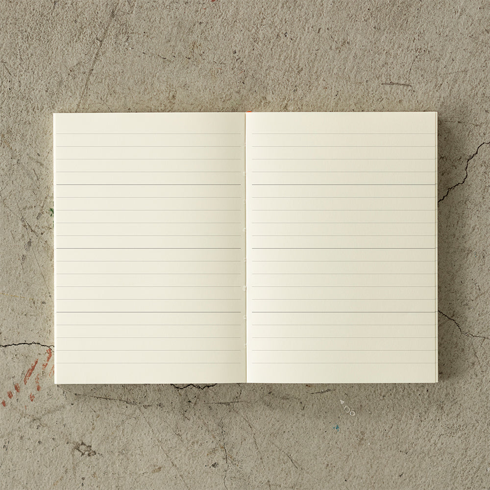 A6 MD Notebook Diary 2026 with a minimalist cream glassine paper cover, featuring monthly block schedule pages, weekly planning sections divided into eight segments, and blank memo pages. Thread-bound for 180-degree flat opening, complete with a slim bookmark string and index label.