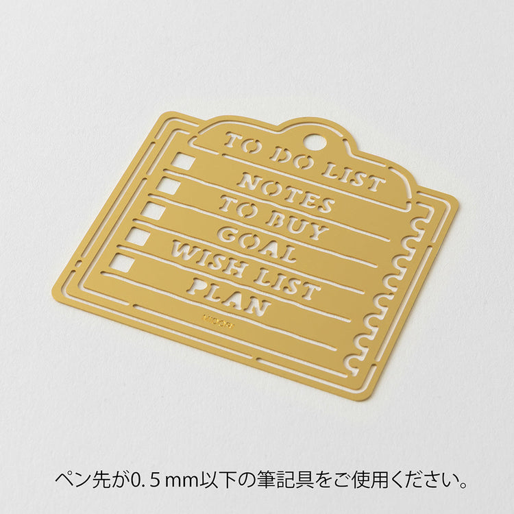 A brass stencil with memo-style motifs including headings and to-do boxes designed for making tidy lists in planners, notebooks, or memos.