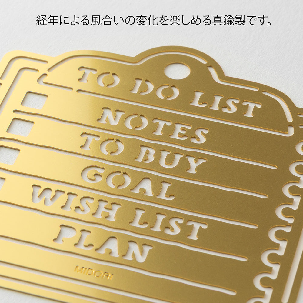 A brass stencil with memo-style motifs including headings and to-do boxes designed for making tidy lists in planners, notebooks, or memos.