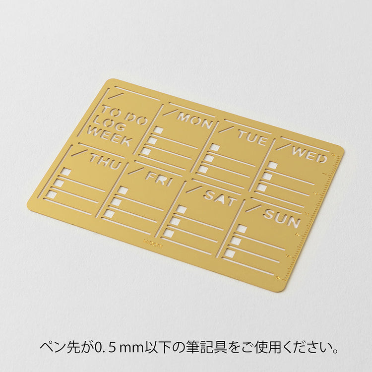A slim brass stencil with a weekly block design, used for tracing neat weekly schedules, to-do lists, and daily records in notebooks.
