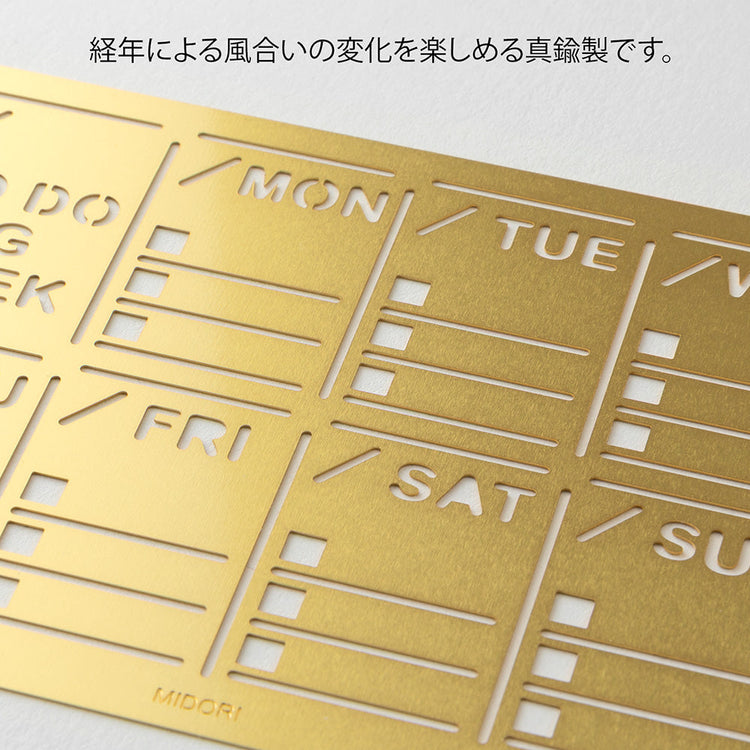 A slim brass stencil with a weekly block design, used for tracing neat weekly schedules, to-do lists, and daily records in notebooks.