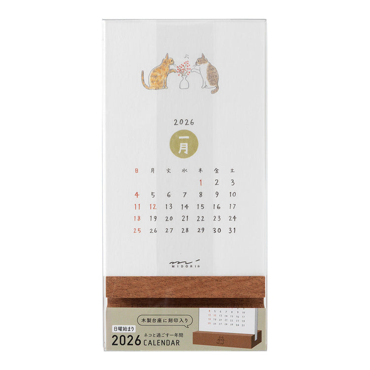 Midori Stand Calendar 2026 – Cat, a slim desktop calendar with a wooden stand, featuring soft, hand-drawn illustrations of cats by Sayo Koizumi in seasonal scenes.