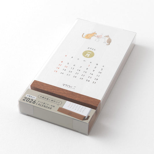 Midori Stand Calendar 2026 – Cat, a slim desktop calendar with a wooden stand, featuring soft, hand-drawn illustrations of cats by Sayo Koizumi in seasonal scenes.