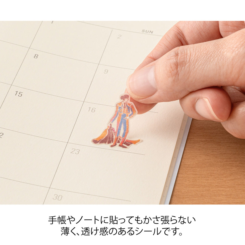 A sheet of Midori Spanish Motifs washi stickers by Yuuka Takamaru, featuring playful illustrations such as flamenco dancers, paella, bulls, guitars, and colorful Spanish tile patterns. Designed in soft pastel hues, these stickers evoke the lively charm and warmth of Spain.