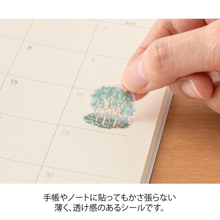 A sheet of Midori Finnish Motifs washi stickers by Yuuka Takamaru, with illustrations of reindeer, Nordic cottages, pine trees, berries, and folk embroidery patterns. The soft, pastel palette evokes the peaceful charm and traditions of Finland.