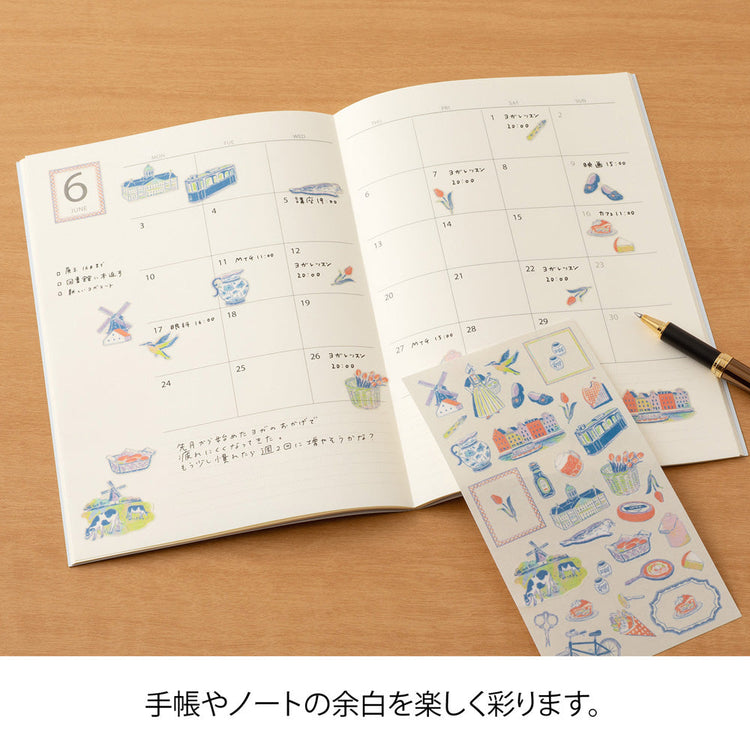 A sheet of Midori Dutch Motifs washi stickers illustrated by Yuuka Takamaru, with charming designs of tulips, windmills, bicycles, clogs, and folk-style frames in soft pastel tones, evoking the cheerful spirit of the Netherlands.