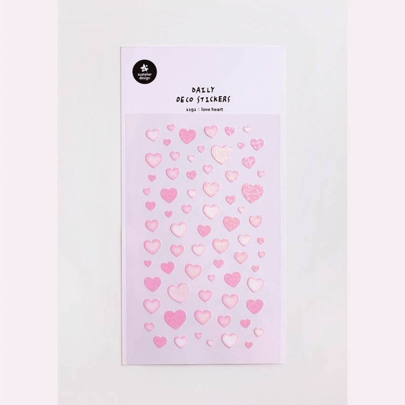 A single sheet of Suatelier Daily Deco Sticker – Love Heart, featuring rows of hand-drawn heart illustrations in different shapes, colors, and sizes on translucent paper.