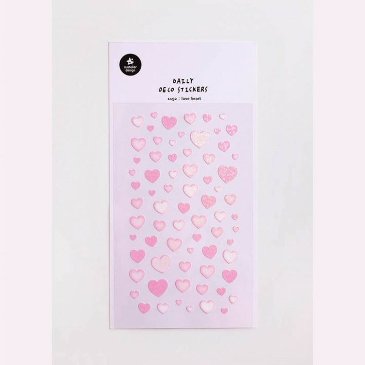 A single sheet of Suatelier Daily Deco Sticker – Love Heart, featuring rows of hand-drawn heart illustrations in different shapes, colors, and sizes on translucent paper.