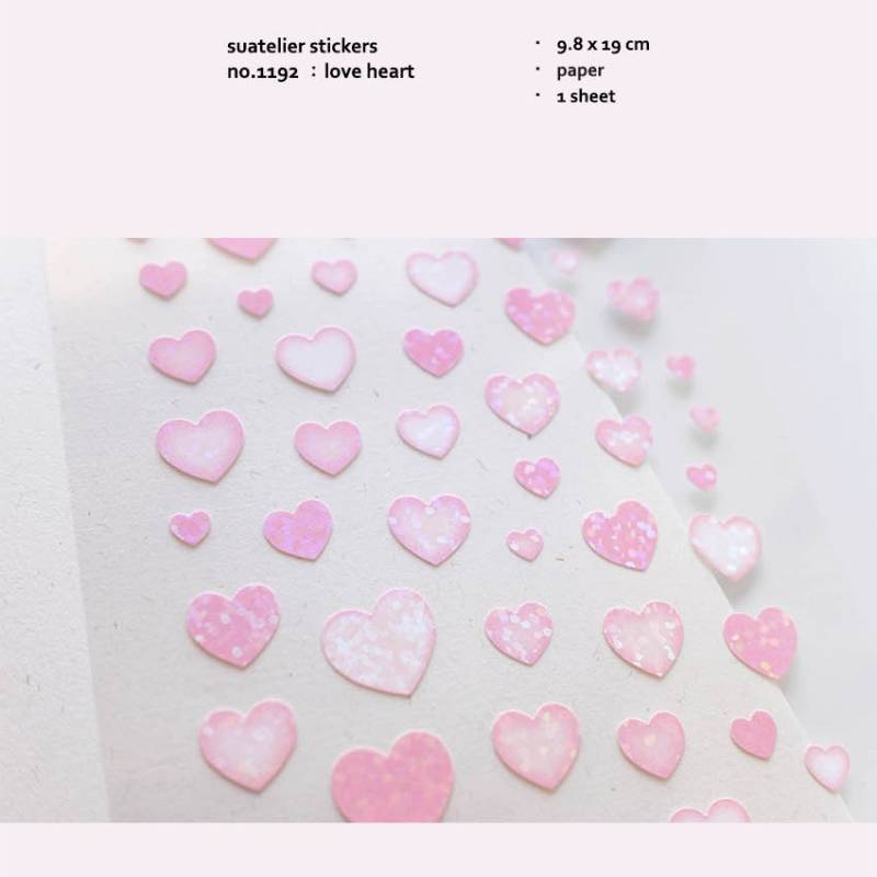 A single sheet of Suatelier Daily Deco Sticker – Love Heart, featuring rows of hand-drawn heart illustrations in different shapes, colors, and sizes on translucent paper.