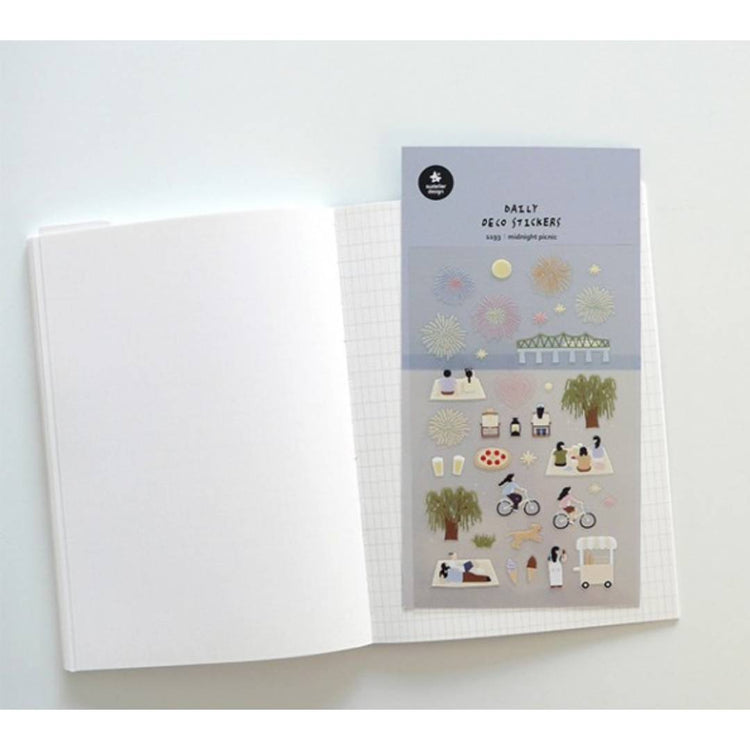 A sheet of decorative stickers featuring illustrations of fireworks, picnic blankets, pizza, drinks, people cycling, dogs, ice cream, and night sky scenes—perfect for journaling and capturing the atmosphere of a summer midnight picnic.